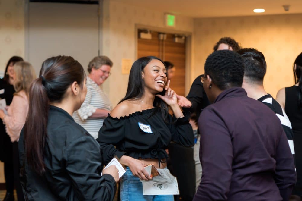 Guests laughing and enjoying a private murder mystery dinner event in Greensboro.