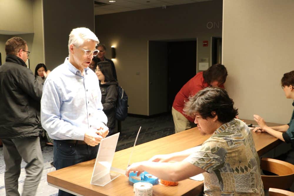 Attendees arriving at the check-in desk at The Dinner Detective corporate event.