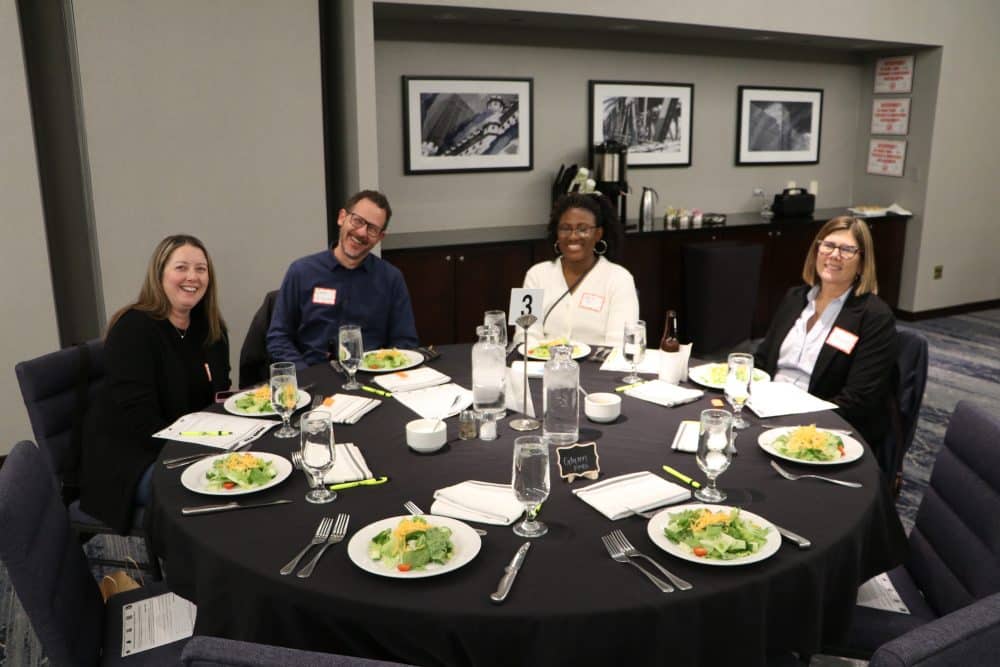 Group of coworkers enjoying dinner at a corporate mystery event.