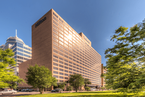 Exterior view of the Hilton Houston Plaza, the venue for The Dinner Detective’s interactive murder mystery dinner shows.