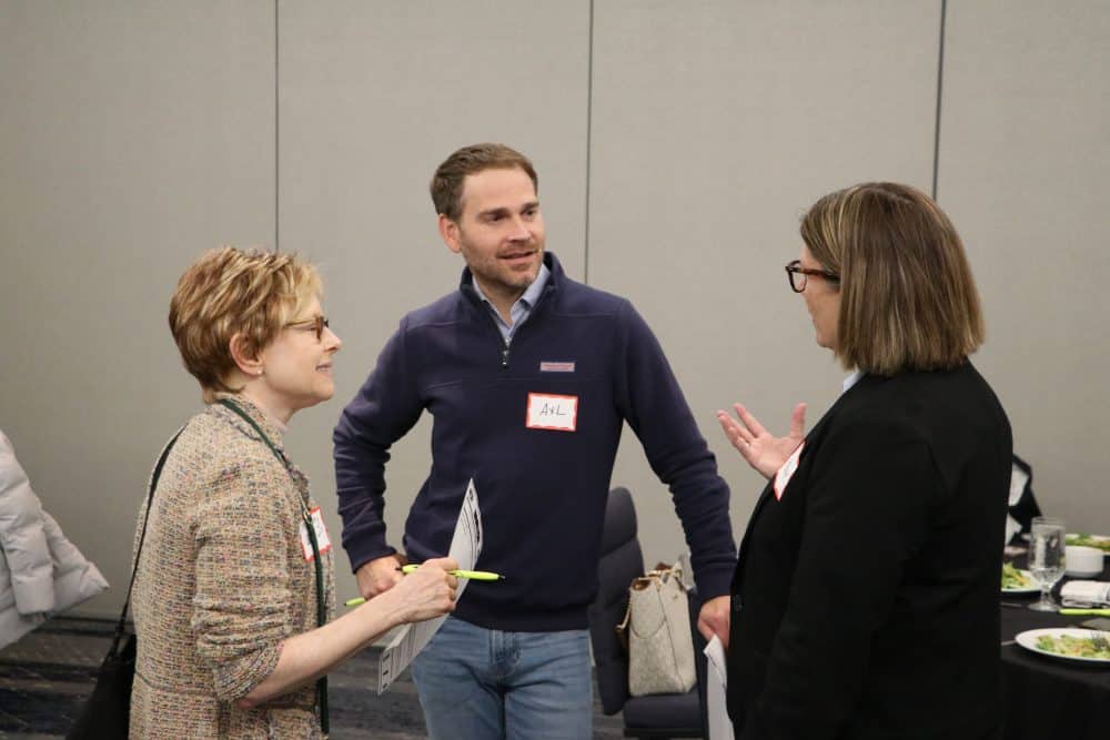 Guests enjoying casual conversation between scenes at a corporate dinner event