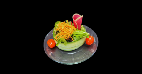 Fresh garden salad served in a halved avocado bowl garnished with carrot shreds and cherry tomatoes.
