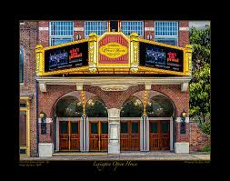Discover the exterior of a vintage theater in Lexington, KY. The prominent arched marquee displays show details against a backdrop of classic brickwork and large windows. Four wooden doors stand beneath brilliant lighting, offering a glimpse into one of the exciting things to do in Lexington, KY.