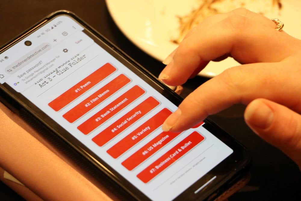 A participant interacting with The Dinner Detective’s digital clue system on a smartphone during a corporate murder mystery event.