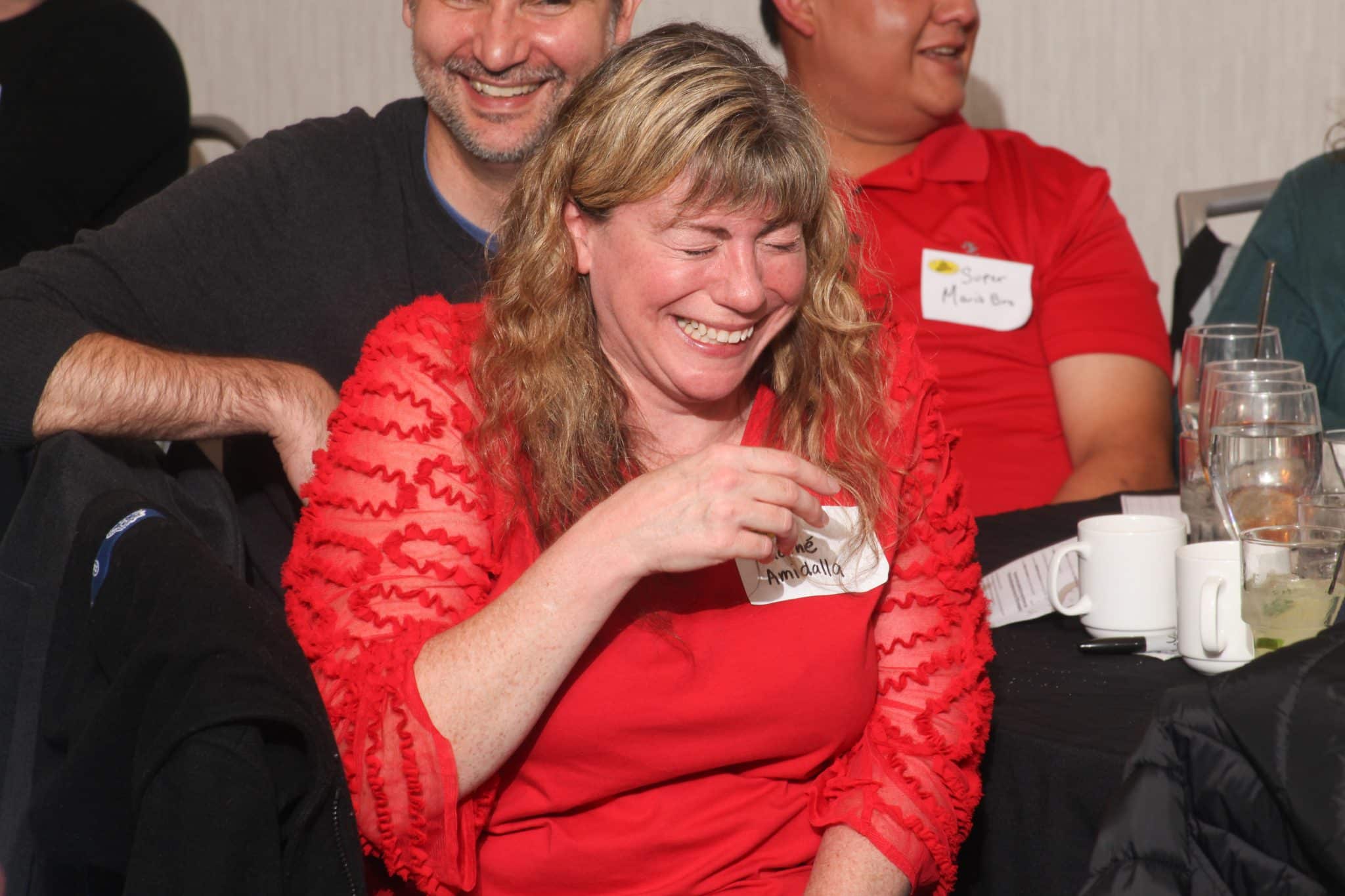 A woman laughs heartily during a moment of surprise at The Dinner Detective Murder Mystery Show in Louisville.