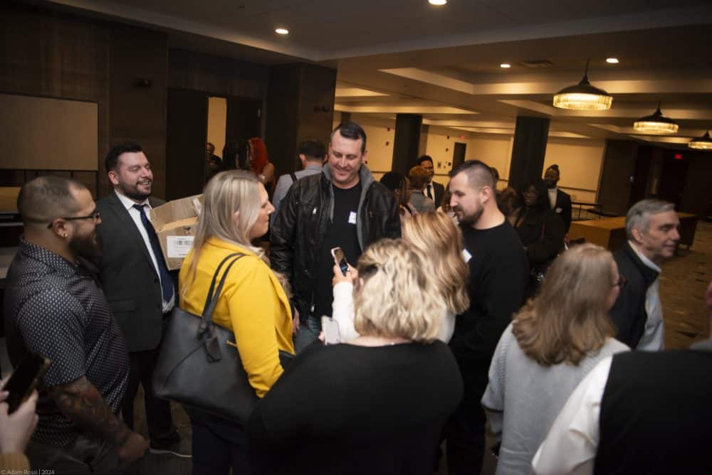 Guests smile and mingle in a crowded room before The Dinner Detective Murder Mystery Show begins in Louisville.