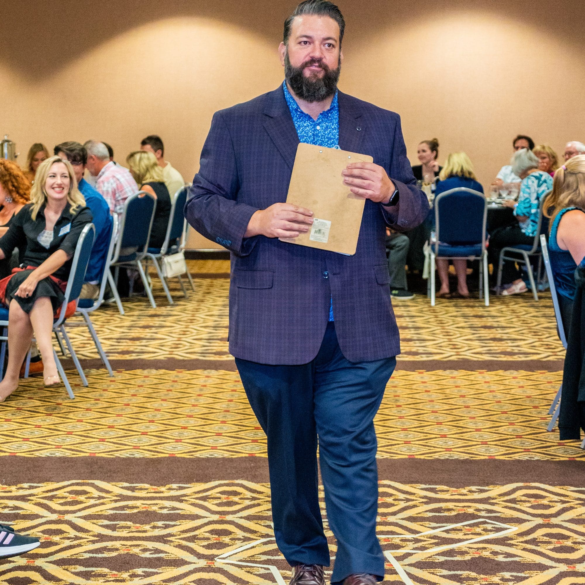 Host interacting with guests during a private murder mystery dinner show by The Dinner Detective in Louisville, KY.