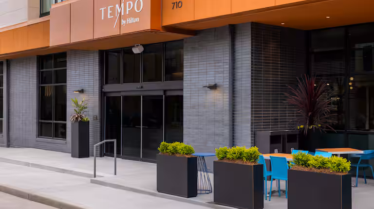 Exterior of Tempo by Hilton Louisville NuLu at sunset, showcasing its contemporary design and inviting entrance.