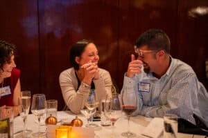 Couple laughing and enjoying wine during The Dinner Detective Louisville interactive murder mystery dinner date night.