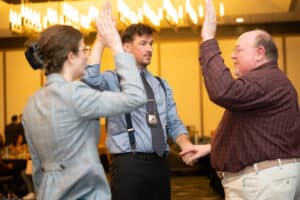 Performer addresses audience with humor during The Dinner Detective Louisville murder mystery dinner show.