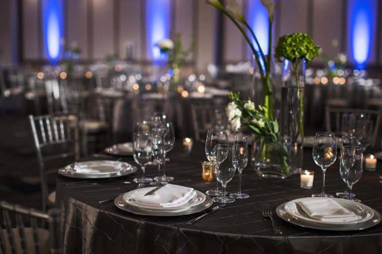 A beautifully decorated dinner table with blue lighting, creating an elegant ambiance.