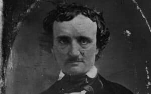 A black and white vintage portrait of a man with curly hair, wearing a dark coat, white shirt, and bow tie. The faded background adds an aged appearance, reminiscent of mystery novelists whose stories echo through the pages of time.
